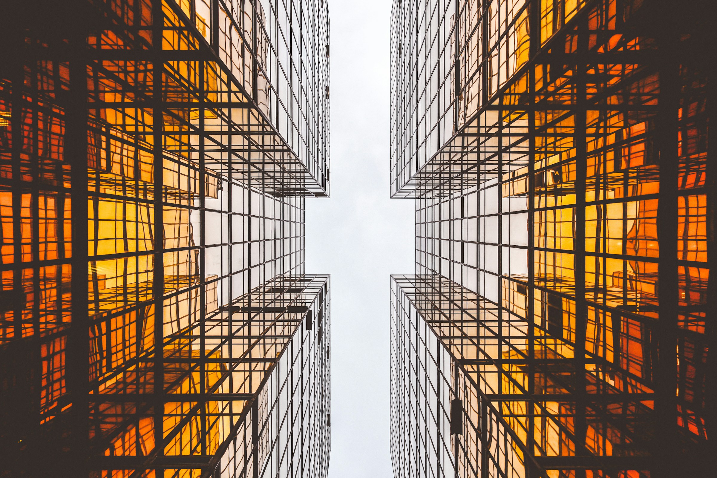 Torres corporativas em vidro, vista em ângulo baixo com reflexos e linhas geométricas